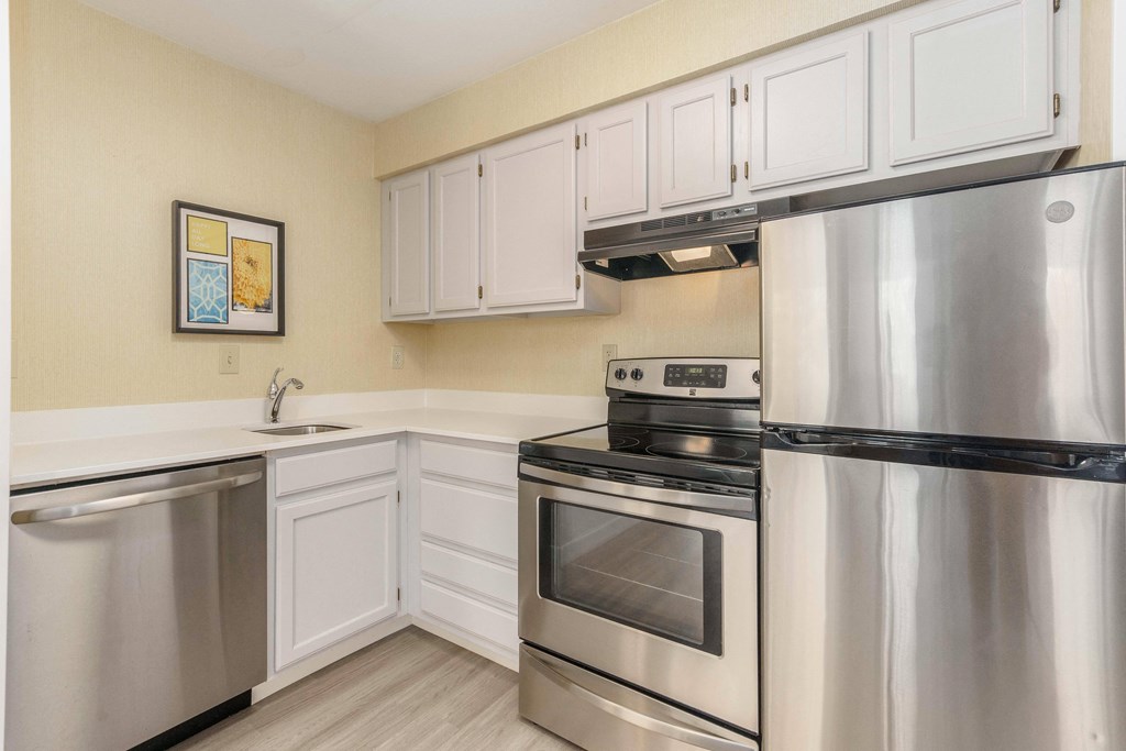 a kitchen with stainless steel appliances and white cabinets